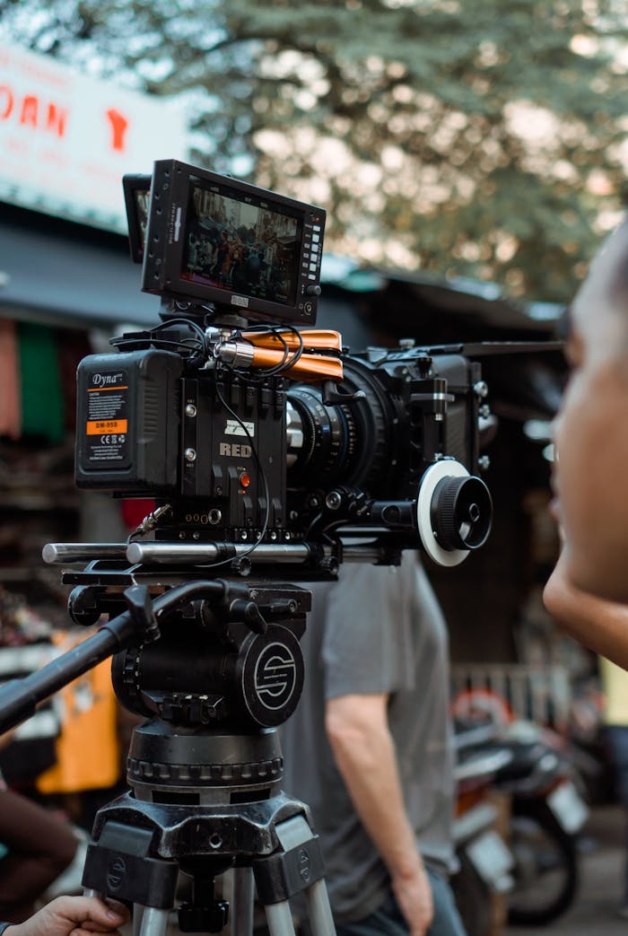 Close-up of professional video camera and crew on an outdoor film set.